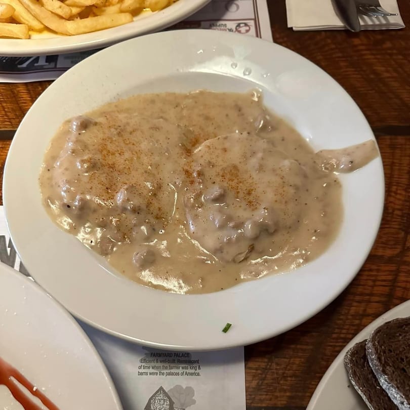Biscuits and gravy, topped with paprika, on a white plate at Chef Darrell's Mountain Diner.